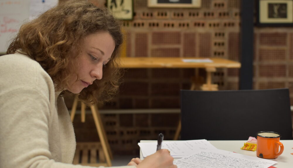 Photo d'Hayva Wernert en train d'écrire durant l'atelier.