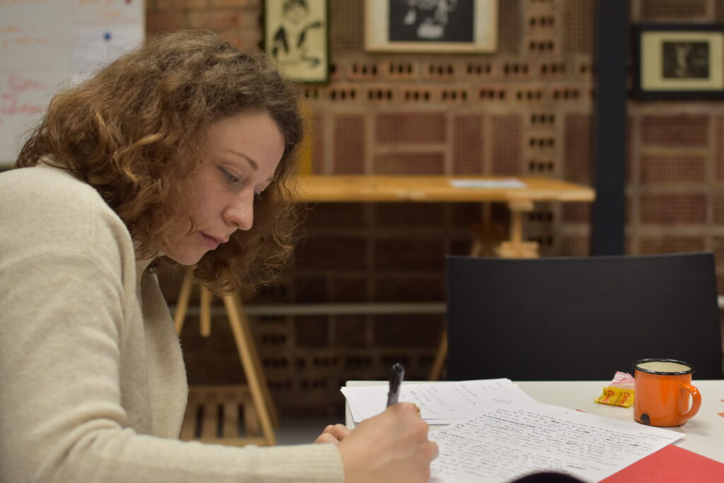 Photo d'Hayva Wernert en train d'écrire durant l'atelier.