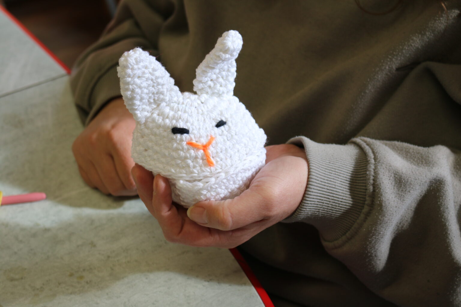 Sandrine nous montre un petit lapin fait en tricot © Hayva Wernert